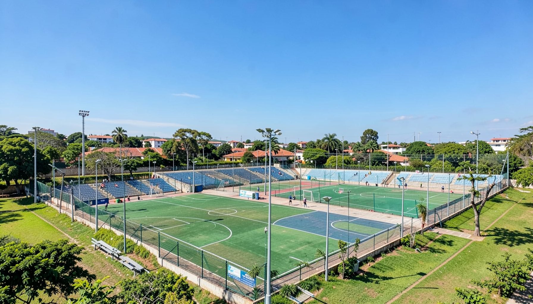 Vista panorámica de la Villa Deportiva en Cacique Catriel, con canchas de básquet y fútbol, áreas verdes y un cielo despejado que refleja la escala del predio deportivo.