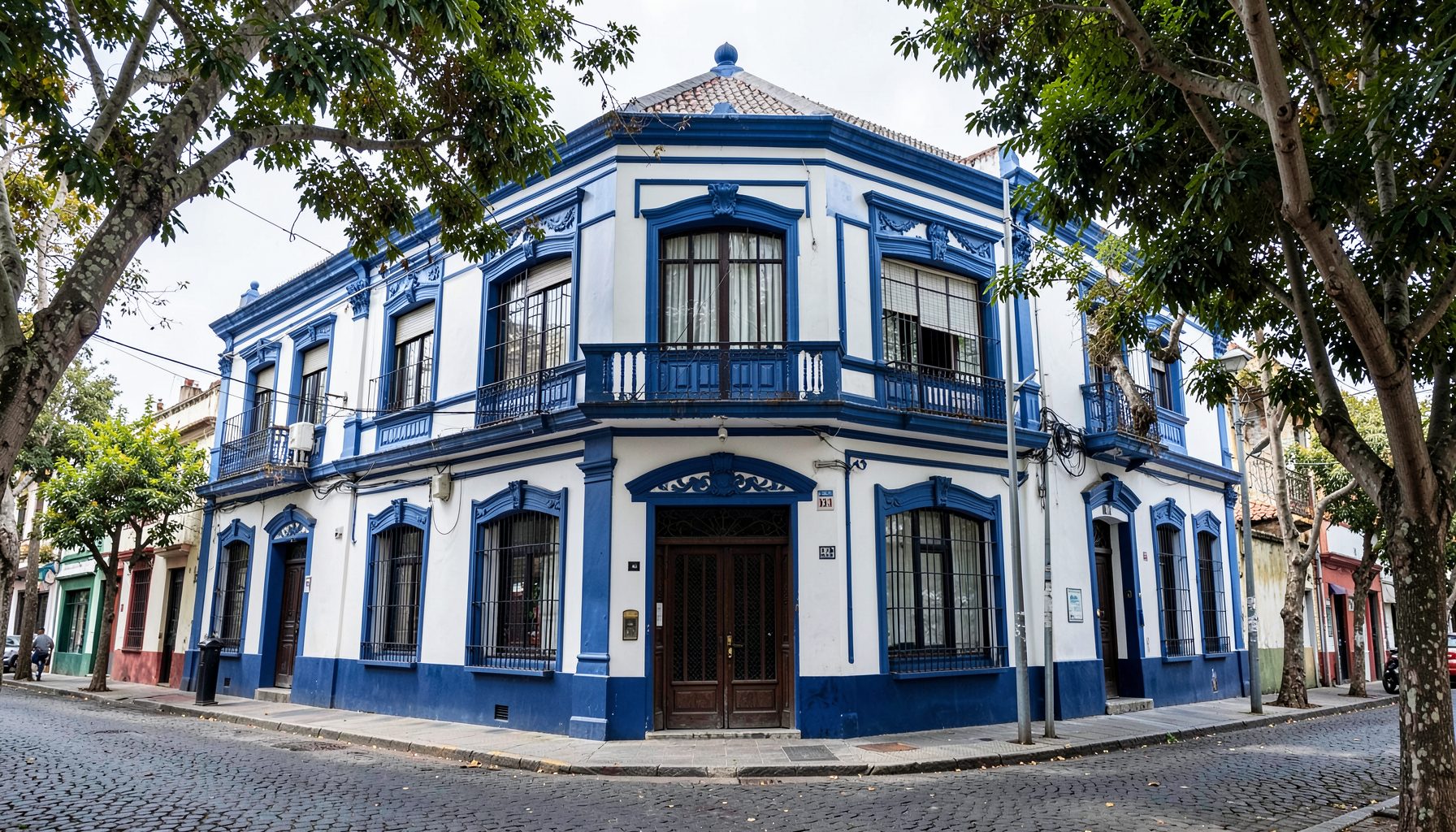 Fachada de la sede social en Garay 2524, un edificio tradicional de dos plantas con detalles en azul marino y blanco, sobre una calle arbolada de Mar del Plata.